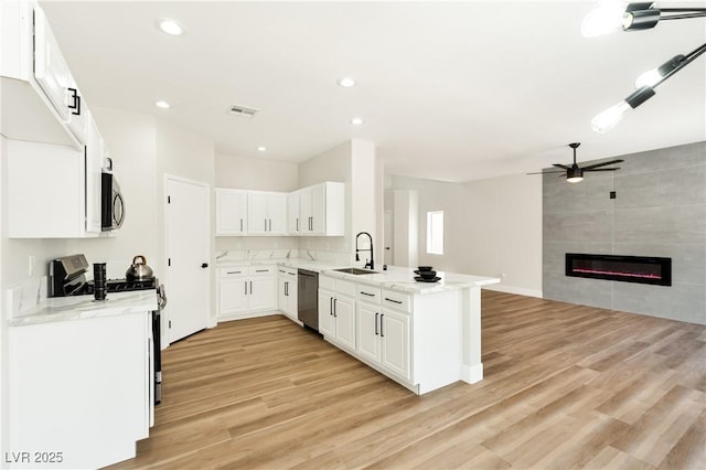 9349 Lakefront Color St, Las Vegas, NV 89178 - kitchen featuring stainless steel appliances, light wood-type flooring, open floor plan, a peninsula, and ceiling fan