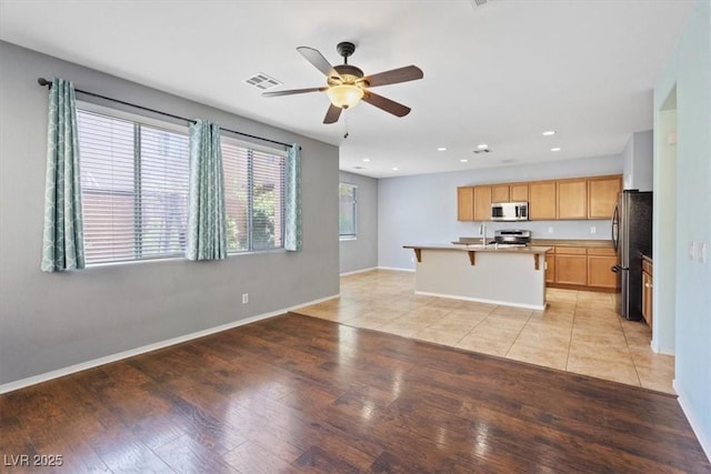 10645 Mount Jefferson Ave, Las Vegas, NV 89166 - kitchen with stainless steel appliances, light wood-type flooring, ceiling fan, light brown cabinetry, and recessed lighting