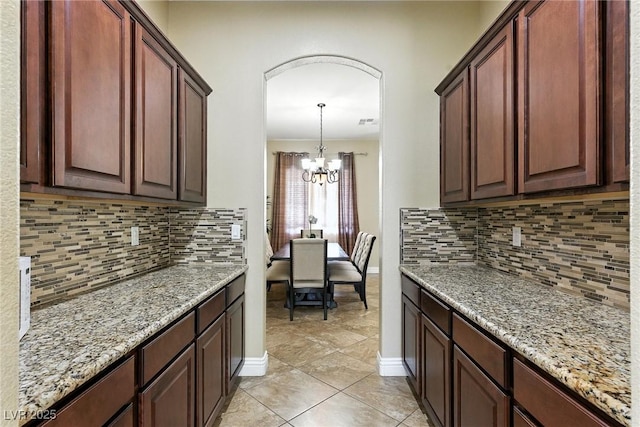 7330 Silent Water Way, Las Vegas, NV 89149 - kitchen with a chandelier, light stone counters, and backsplash