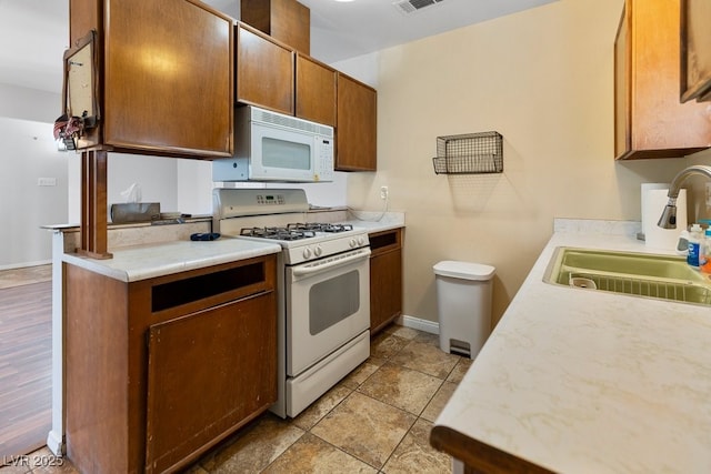 7221 Alta Dr, Las Vegas, NV 89145 - kitchen with white appliances, light countertops, and brown cabinetry
