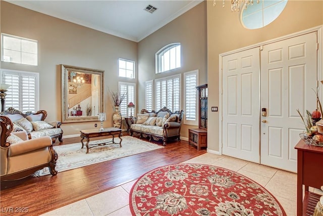 109 N Buteo Woods Ln, Las Vegas, NV 89144 - tiled foyer entrance with ornamental molding, a high ceiling, and a chandelier