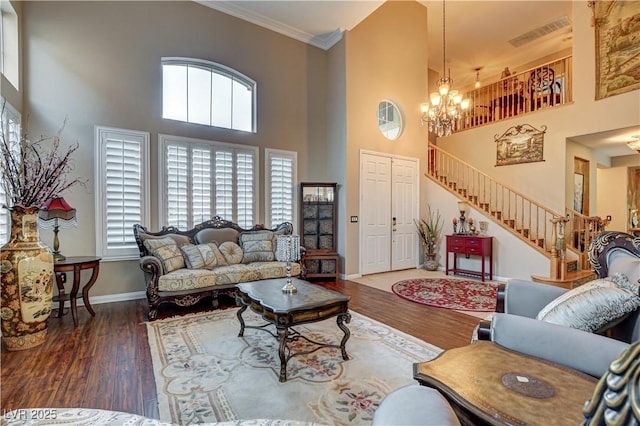 109 N Buteo Woods Ln, Las Vegas, NV 89144 - living room with a high ceiling, stairs, a chandelier, ornamental molding, and wood finished floors