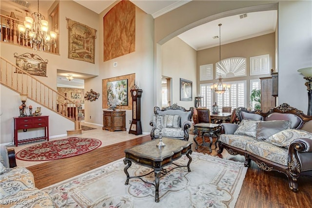 109 N Buteo Woods Ln, Las Vegas, NV 89144 - living area featuring a chandelier, arched walkways, a high ceiling, wood finished floors, and stairs