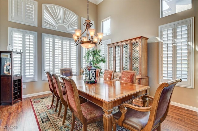 109 N Buteo Woods Ln, Las Vegas, NV 89144 - dining area with a chandelier, healthy amount of natural light, wood finished floors, and a high ceiling