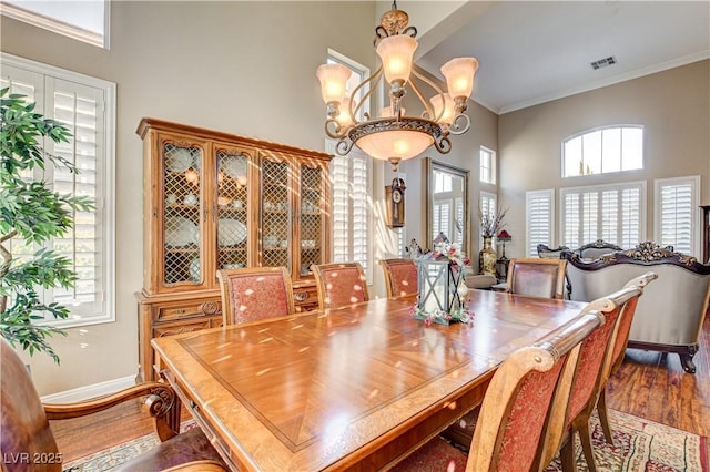109 N Buteo Woods Ln, Las Vegas, NV 89144 - dining area with wood finished floors, ornamental molding, a chandelier, and a towering ceiling