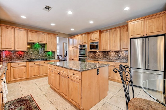 109 N Buteo Woods Ln, Las Vegas, NV 89144 - kitchen featuring stainless steel appliances, a kitchen island, light tile patterned floors, dark stone countertops, and recessed lighting