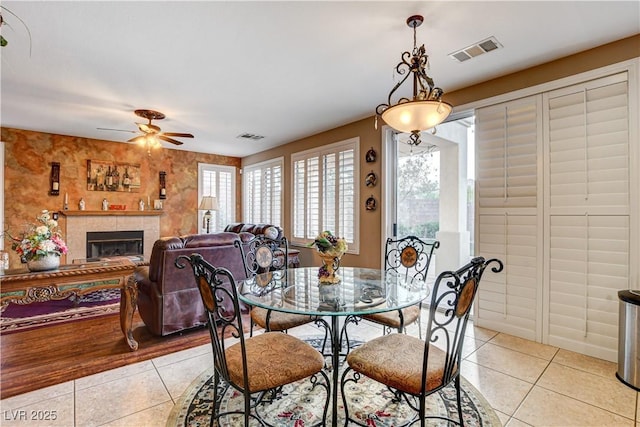 109 N Buteo Woods Ln, Las Vegas, NV 89144 - dining room with light tile patterned floors, a ceiling fan, and a tiled fireplace