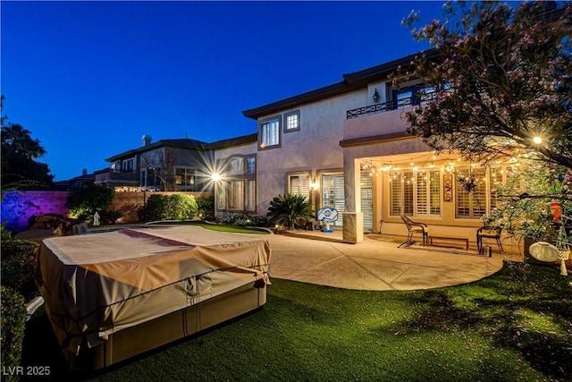 109 N Buteo Woods Ln, Las Vegas, NV 89144 - back of house at twilight featuring a balcony, stucco siding, and a patio