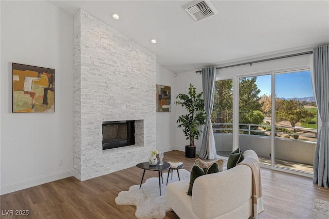 1613 Iron Ridge Dr, Las Vegas, NV 89117 - living room featuring wood finished floors, a stone fireplace, lofted ceiling, and recessed lighting