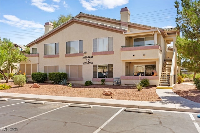5710 E Tropicana Ave Unit 1035, Las Vegas, NV 89122 - view of building exterior featuring uncovered parking and stairs