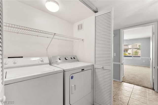 5710 E Tropicana Ave Unit 1035, Las Vegas, NV 89122 - laundry room with washer and dryer, light colored carpet, and light tile patterned floors