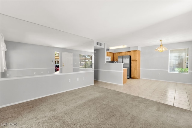 5710 E Tropicana Ave Unit 1035, Las Vegas, NV 89122 - unfurnished living room featuring light colored carpet, a chandelier, and light tile patterned floors