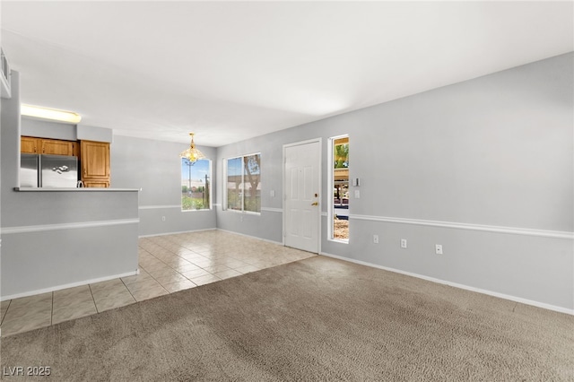 5710 E Tropicana Ave Unit 1035, Las Vegas, NV 89122 - unfurnished living room featuring light colored carpet, light tile patterned flooring, and a chandelier