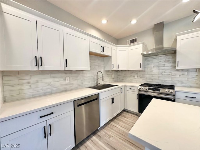 9000 Las Vegas Blvd Unit 1078, Las Vegas, NV 89123 - kitchen with stainless steel appliances, wall chimney range hood, light countertops, white cabinetry, and light wood-style flooring