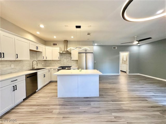 9000 Las Vegas Blvd Unit 1078, Las Vegas, NV 89123 - kitchen with stainless steel appliances, wall chimney range hood, a kitchen island, backsplash, and light wood-style flooring