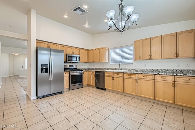 3308 Morning Wind Ln, Las Vegas, NV 89129 - kitchen featuring appliances with stainless steel finishes, light stone counters, a chandelier, light brown cabinets, and light tile patterned flooring