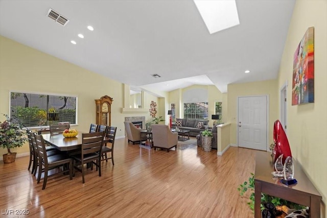 2408 Sunset Beach Ln, Las Vegas, NV 89128 - dining space with vaulted ceiling, a fireplace, light wood finished floors, and recessed lighting