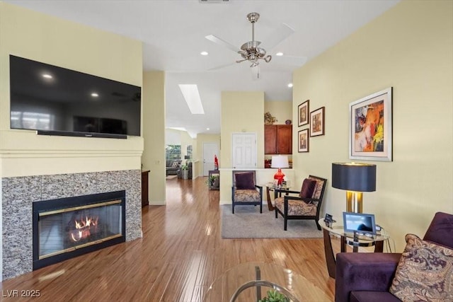 2408 Sunset Beach Ln, Las Vegas, NV 89128 - living area featuring a ceiling fan, wood finished floors, a skylight, a glass covered fireplace, and recessed lighting