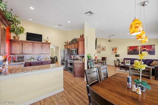 2408 Sunset Beach Ln, Las Vegas, NV 89128 - kitchen featuring appliances with stainless steel finishes, decorative backsplash, light wood-style floors, a peninsula, and ceiling fan