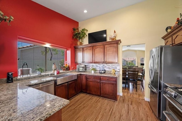 2408 Sunset Beach Ln, Las Vegas, NV 89128 - kitchen with stainless steel appliances, a high ceiling, light wood-style floors, light stone countertops, and recessed lighting