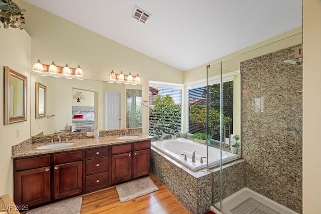 2408 Sunset Beach Ln, Las Vegas, NV 89128 - full bath featuring wood finished floors, lofted ceiling, a bath, double vanity, and a stall shower