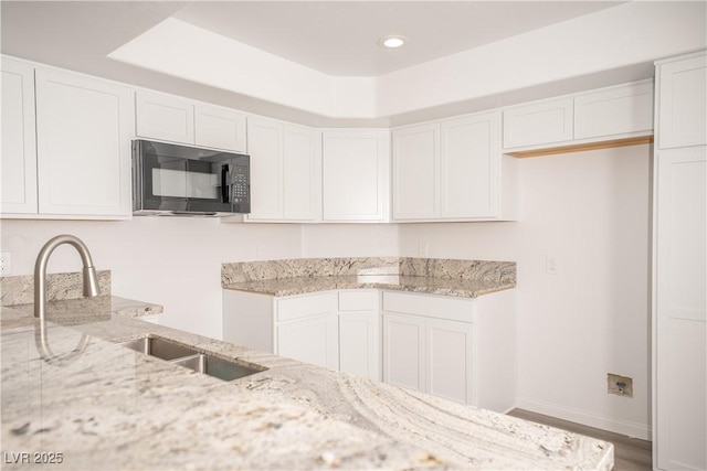 7950 W Flamingo Rd Unit 1009, Las Vegas, NV 89147 - kitchen featuring black microwave, light stone countertops, white cabinetry, and recessed lighting