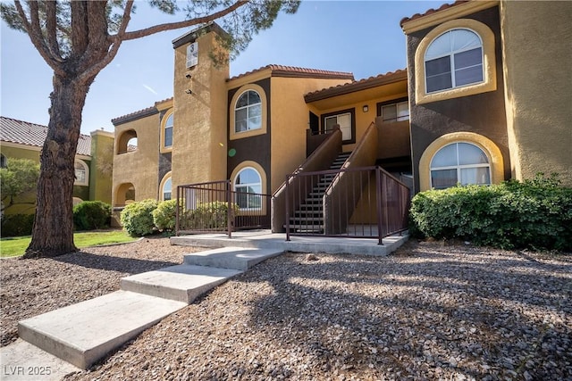 7950 W Flamingo Rd Unit 1009, Las Vegas, NV 89147 - view of front of home with stucco siding, a tile roof, stairway, and a chimney