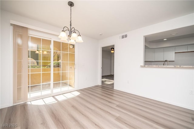 7950 W Flamingo Rd Unit 1009, Las Vegas, NV 89147 - spare room featuring wood finished floors and a chandelier