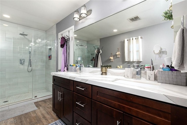 6457 Celeste Ave, Las Vegas, NV 89107 - bathroom featuring a shower stall, wood finished floors, double vanity, a spacious closet, and recessed lighting