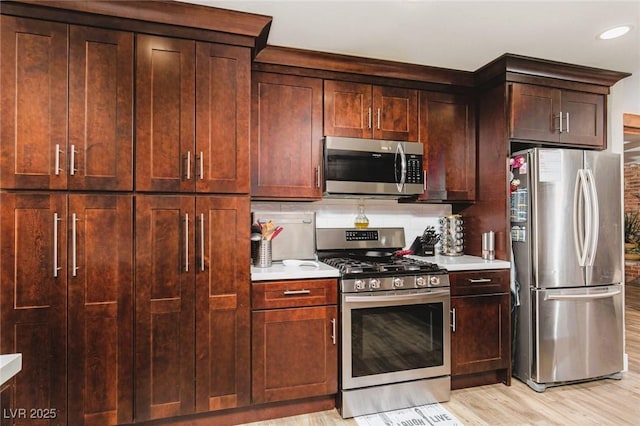 6457 Celeste Ave, Las Vegas, NV 89107 - kitchen featuring appliances with stainless steel finishes, light countertops, light wood-style flooring, recessed lighting, and dark brown cabinets
