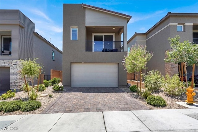 9835 Mojave Mountain St, Las Vegas, NV 89166 - contemporary home featuring a balcony, decorative driveway, stucco siding, and a garage