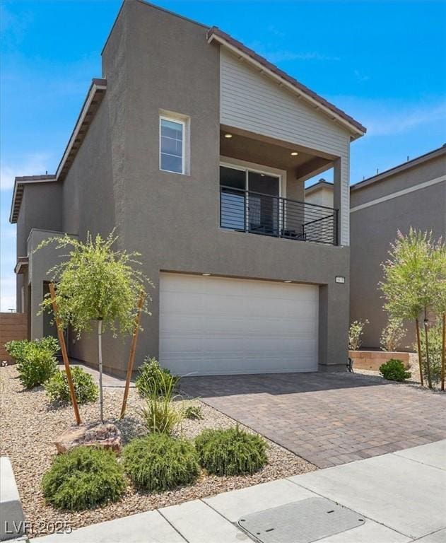 9835 Mojave Mountain St, Las Vegas, NV 89166 - modern home featuring a garage, decorative driveway, stucco siding, and a balcony