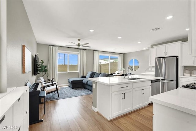 9835 Mojave Mountain St, Las Vegas, NV 89166 - kitchen featuring stainless steel appliances, light countertops, light wood finished floors, open floor plan, and recessed lighting