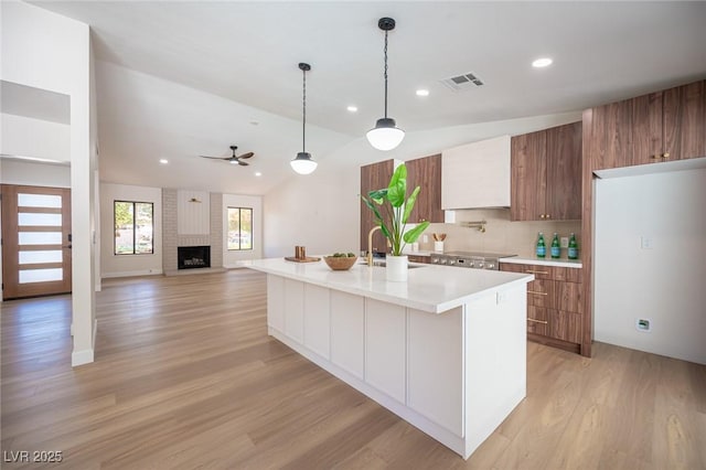 4594 Cabo Ln, Las Vegas, NV 89121 - kitchen featuring ceiling fan, modern cabinets, brown cabinetry, lofted ceiling, and recessed lighting