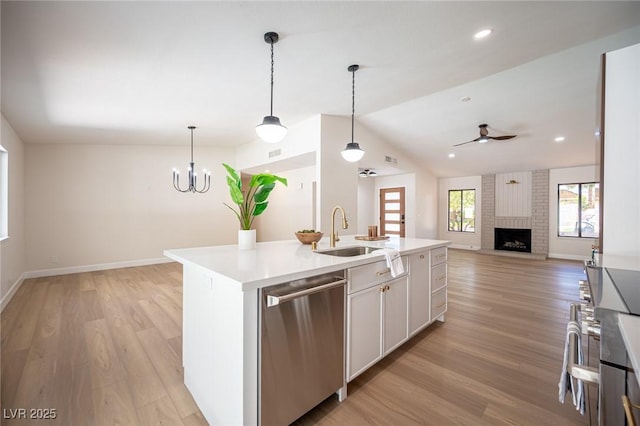 4594 Cabo Ln, Las Vegas, NV 89121 - kitchen featuring stainless steel dishwasher, a brick fireplace, open floor plan, ceiling fan, and light countertops