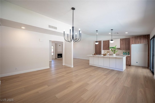 4594 Cabo Ln, Las Vegas, NV 89121 - kitchen with light countertops, light wood-style floors, a chandelier, a kitchen island, and recessed lighting