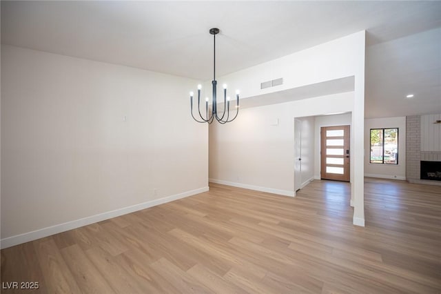 4594 Cabo Ln, Las Vegas, NV 89121 - spare room featuring a chandelier, light wood-type flooring, a fireplace, and recessed lighting