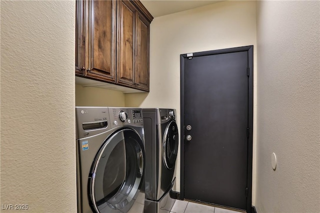 235 Calvino Ave, Las Vegas, NV 89183 - laundry area featuring washing machine and dryer, cabinet space, a textured wall, and light tile patterned flooring