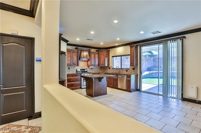 235 Calvino Ave, Las Vegas, NV 89183 - kitchen with ornamental molding, stainless steel appliances, premium range hood, tasteful backsplash, and a kitchen island