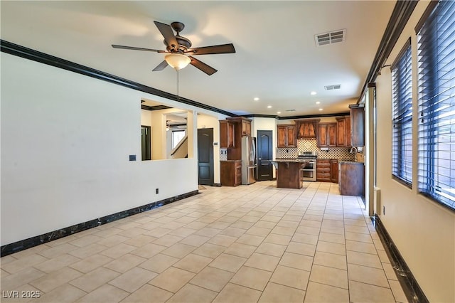 235 Calvino Ave, Las Vegas, NV 89183 - kitchen with a kitchen island, healthy amount of natural light, ceiling fan, crown molding, and appliances with stainless steel finishes