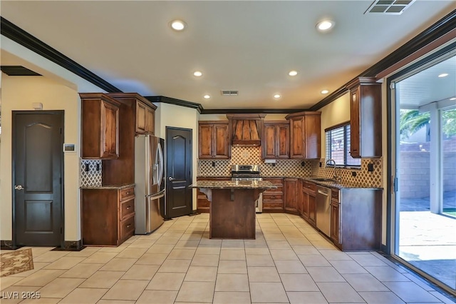 235 Calvino Ave, Las Vegas, NV 89183 - kitchen with stainless steel appliances, custom exhaust hood, ornamental molding, a center island, and tasteful backsplash