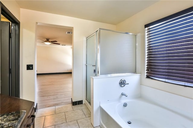 235 Calvino Ave, Las Vegas, NV 89183 - full bathroom featuring a ceiling fan, a bath, a shower stall, and tile patterned flooring