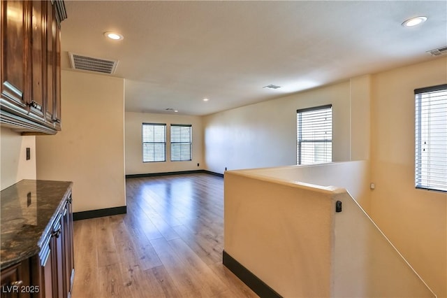 235 Calvino Ave, Las Vegas, NV 89183 - kitchen featuring light wood-type flooring, recessed lighting, dark brown cabinetry, and dark stone counters