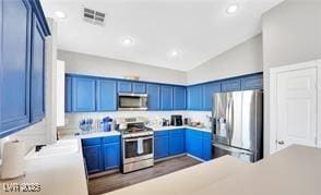 11018 Salernes St, Las Vegas, NV 89141 - kitchen with stainless steel appliances, lofted ceiling, blue cabinetry, light countertops, and recessed lighting