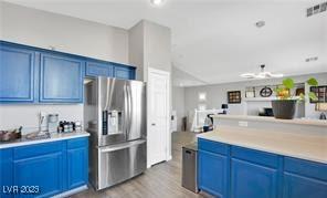 11018 Salernes St, Las Vegas, NV 89141 - kitchen featuring stainless steel refrigerator with ice dispenser, blue cabinets, wood finished floors, and light countertops