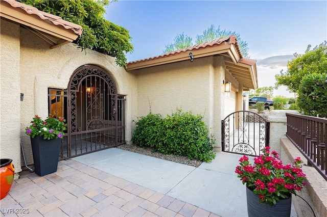 3227 Paintedhills Ave, Las Vegas, NV 89120 - property entrance with a gate, stucco siding, and a tile roof