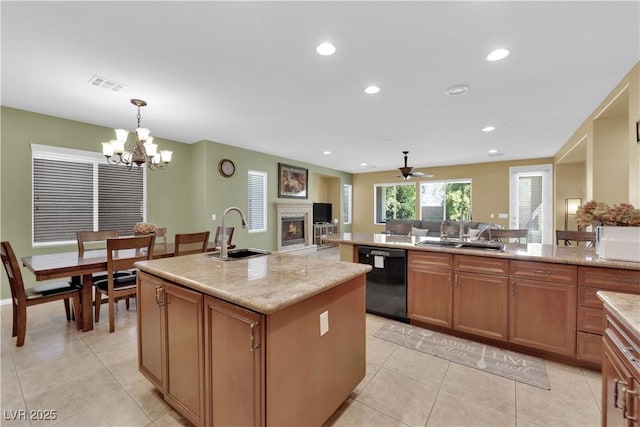 9516 Bluff Ledge Ave, Las Vegas, NV 89149 - kitchen with black dishwasher, a warm lit fireplace, light tile patterned flooring, pendant lighting, and recessed lighting
