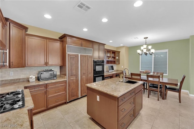 9516 Bluff Ledge Ave, Las Vegas, NV 89149 - kitchen featuring gas stovetop, a kitchen island with sink, tasteful backsplash, light tile patterned floors, and recessed lighting
