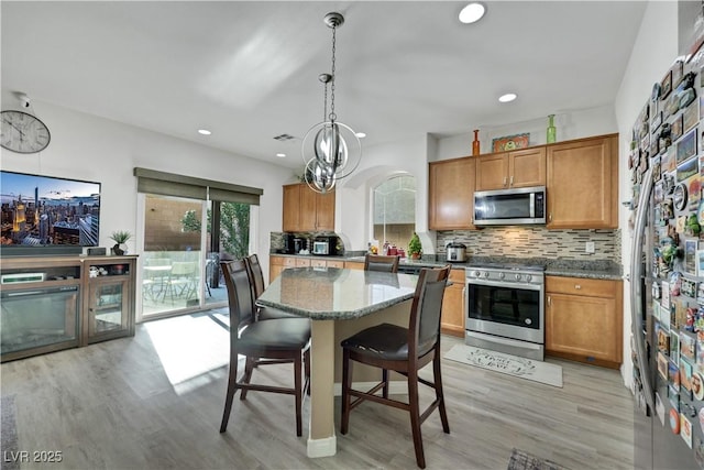 10167 Bishops Peak Ct, Las Vegas, NV 89141 - kitchen featuring stainless steel appliances, a center island, tasteful backsplash, brown cabinets, and recessed lighting
