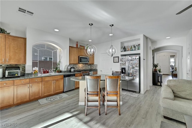 10167 Bishops Peak Ct, Las Vegas, NV 89141 - kitchen featuring stainless steel appliances, brown cabinetry, light wood-style flooring, and recessed lighting